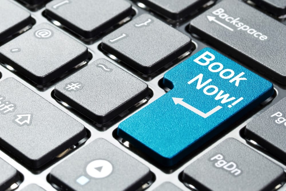 A blue button with the word "book now" on it, designed for making reservations using RoverPass in Canada.