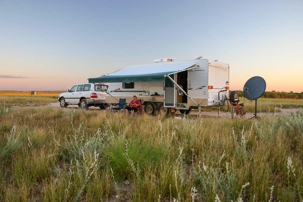 A new caravan manufactured by New Caravan Manufacturing parked in the middle of a grassy field as part of a State Initiative in the City of Whittlesea.