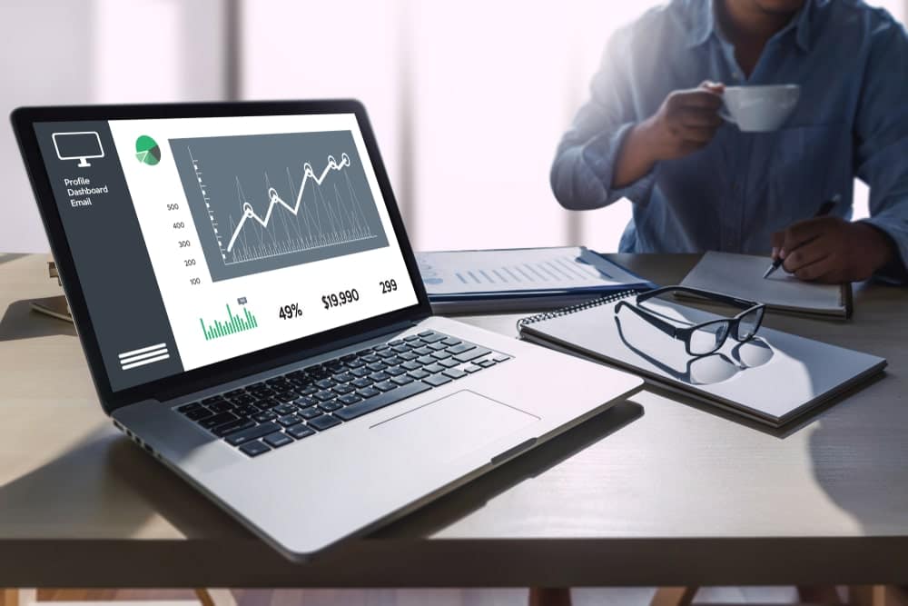 A man is sitting at a desk with a laptop displaying Q3 2021 financial results.