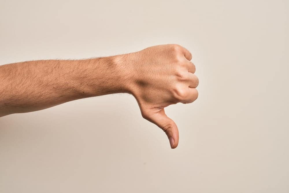 A man's hand showing a thumbs down sign in response to the proposed Berthoud Campground, anticipating backlash.
