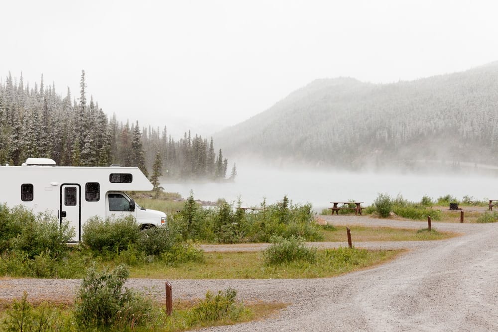 A white RV parked near a lake.