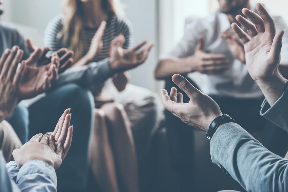 A group of people clapping their hands together.