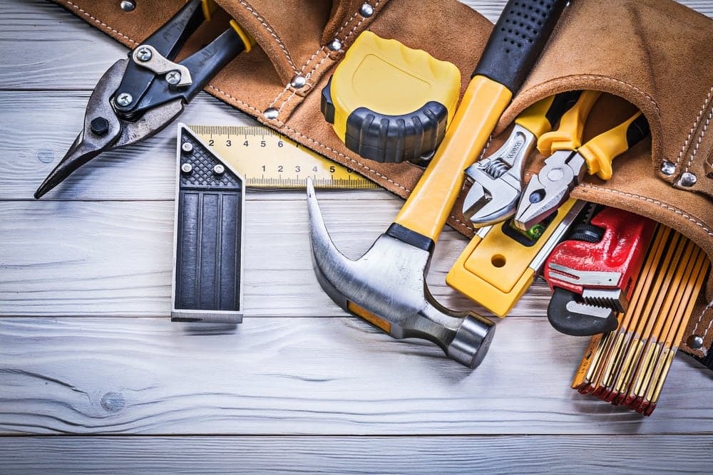 Tools in a leather tool bag on a wooden table at a campground in Manitoba.