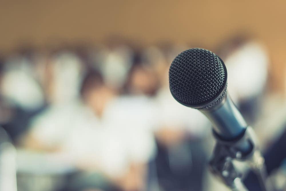 An image of a microphone in front of a group of people.