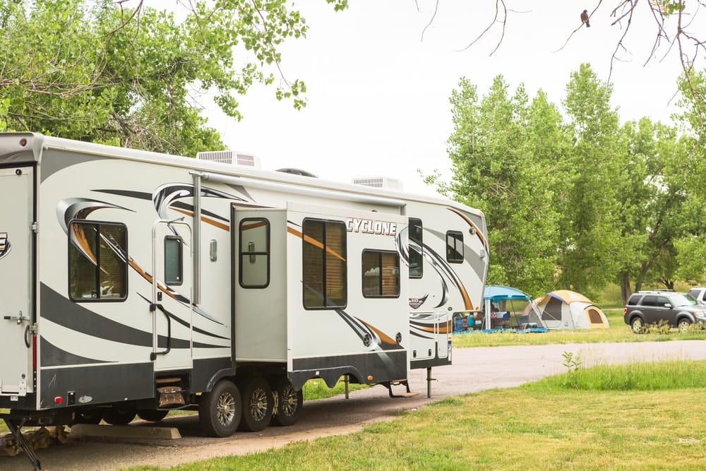 A proposed black and white rv parked in a grassy area.