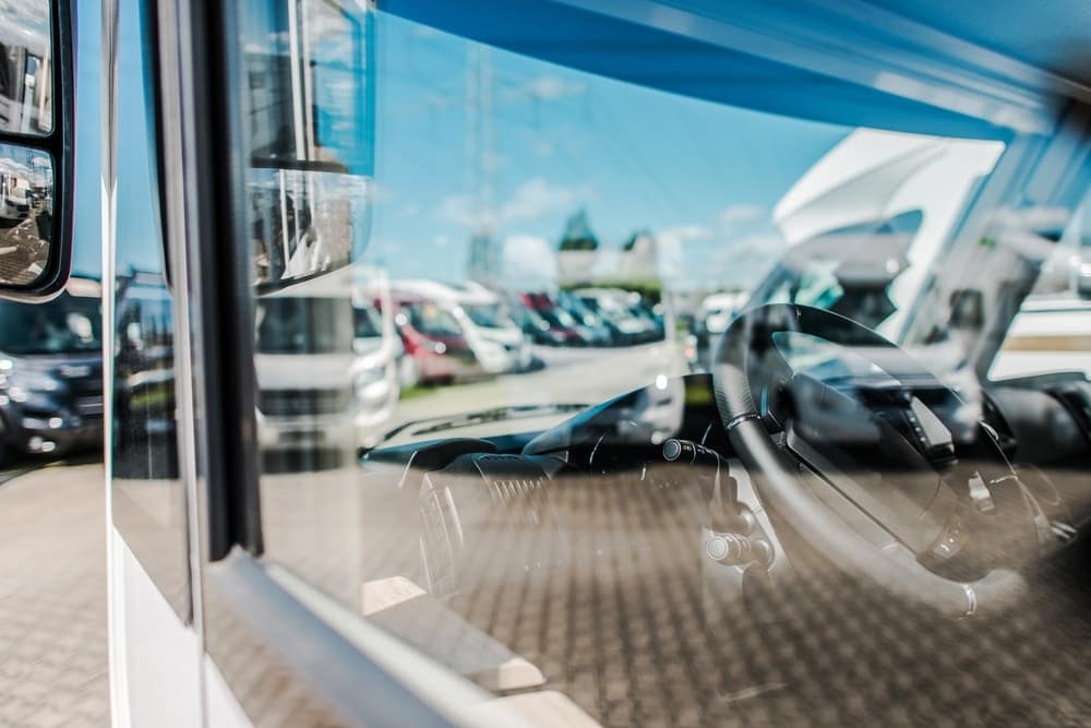 A reflection of an RV parked in a Florida parking lot.