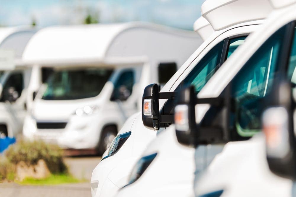 An average row of white rvs parked next to each other.