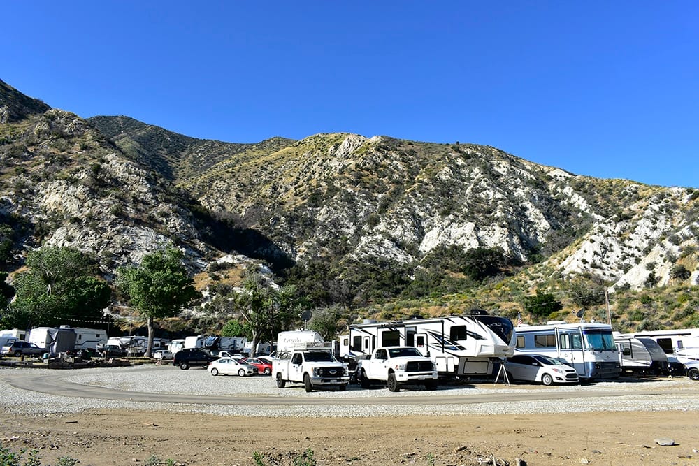 A group of RV's parked in a dirt lot, catering to the needs of Santa Clarita residents.