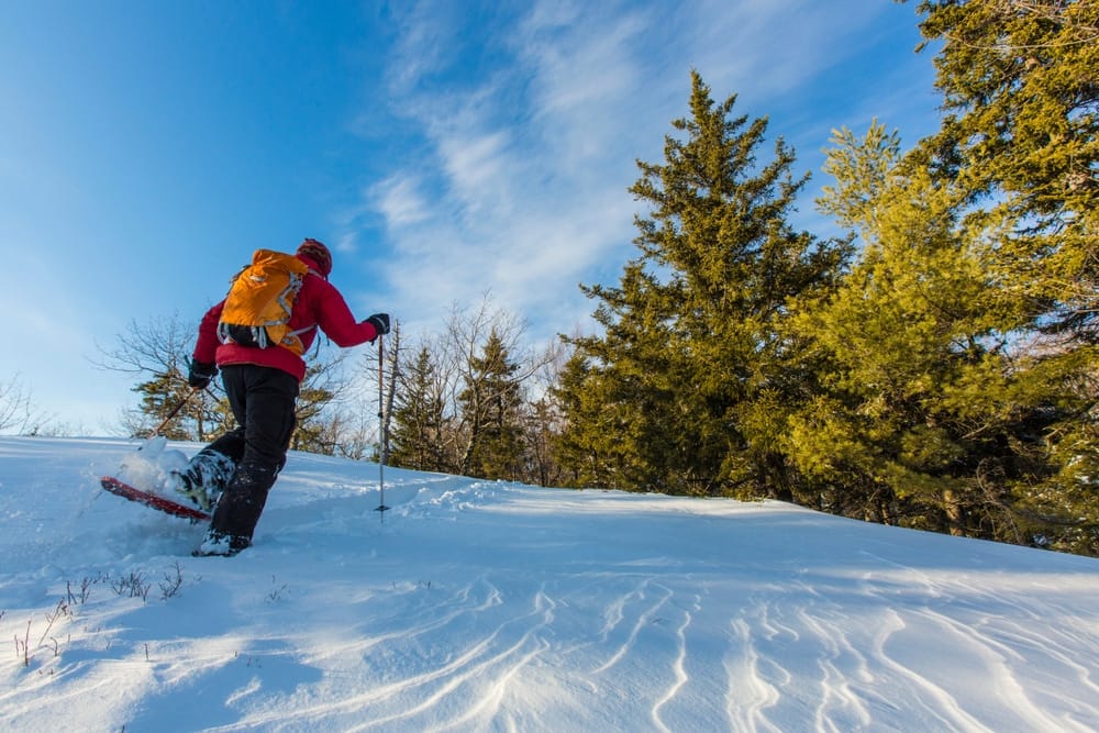 A man is snowboarding down a snowy hill.