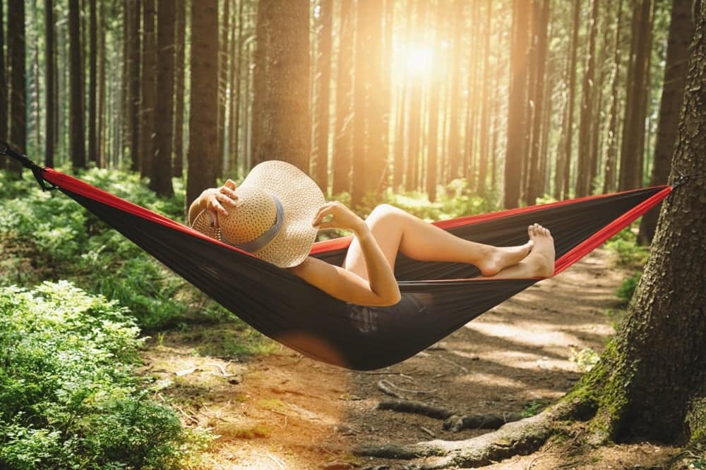 A woman relaxing in a hammock at a campground in Michigan.