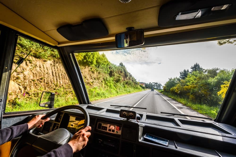 A man driving a truck down a country road.