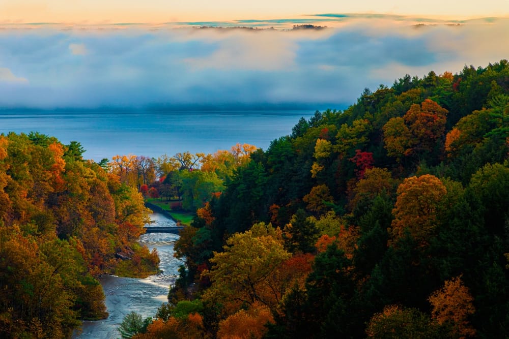 A scenic view of a river and trees in the fall, captured during this year's record season at New York State Campgrounds.