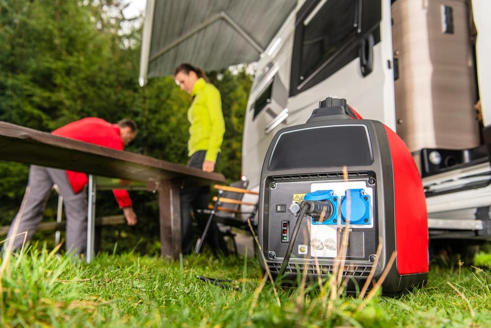A CARB-compliant RV equipped with a portable generator rests peacefully on the grass.