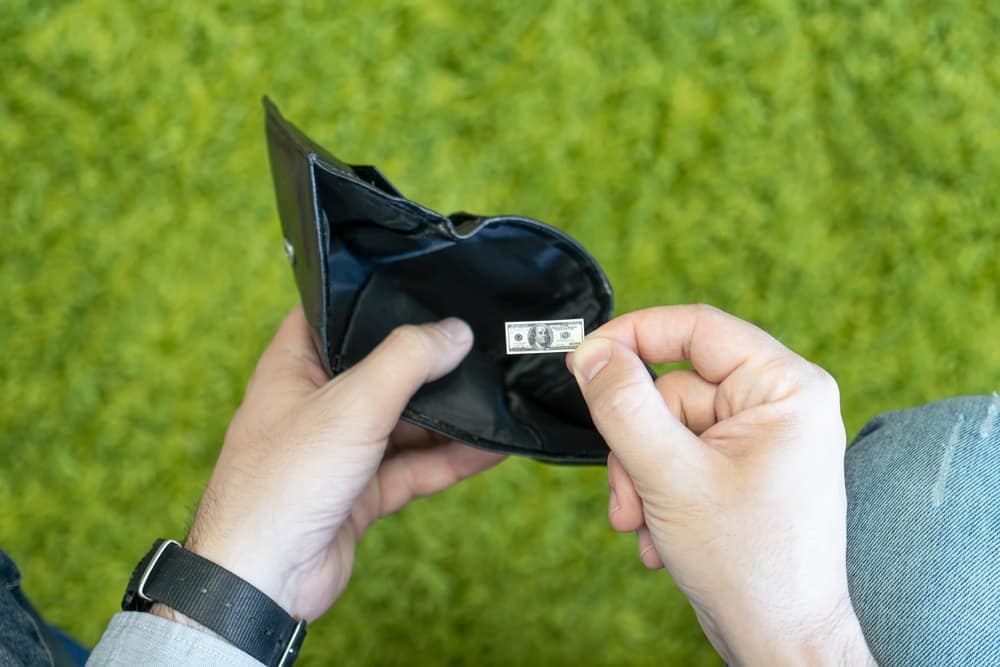 A man's hand holding a wallet with a micro-sd card in it, depicting the expanding reach of digital currency.