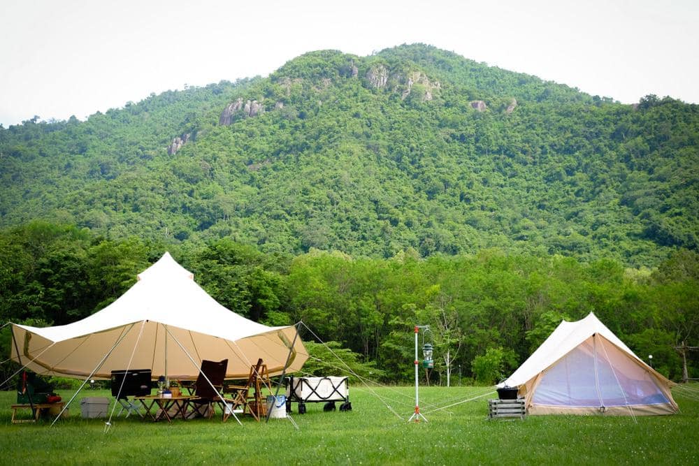 Two camping tents set up in a field with mountains in the background on private property in San Luis Obispo County.
