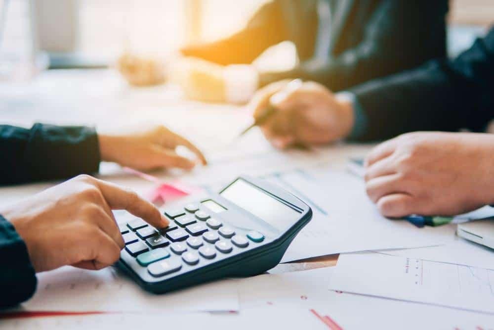 A group of business people using a calculator.