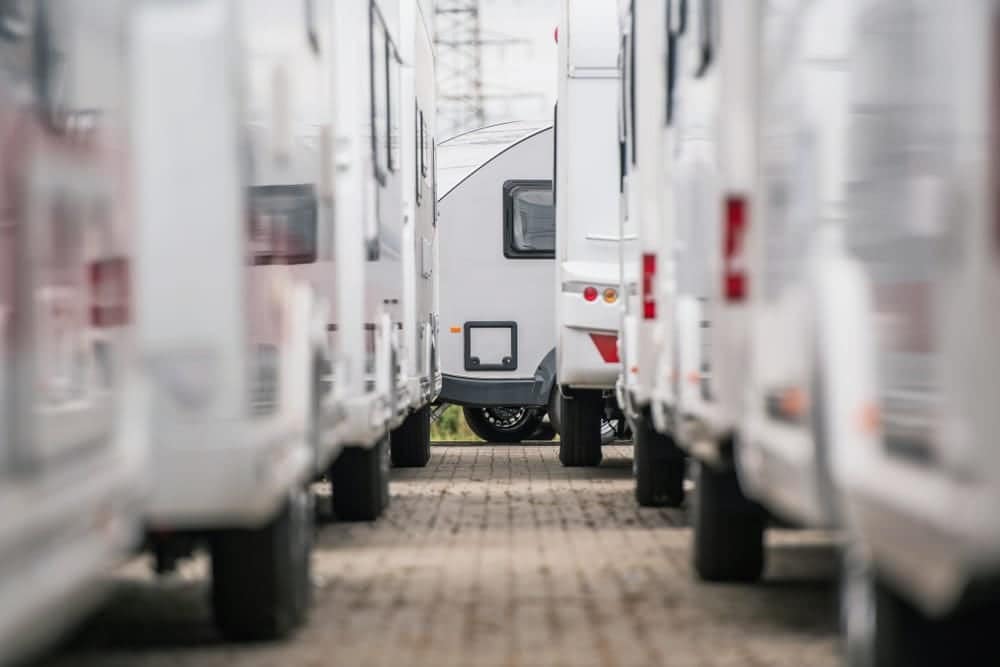 A row of rvs parked in a parking lot.