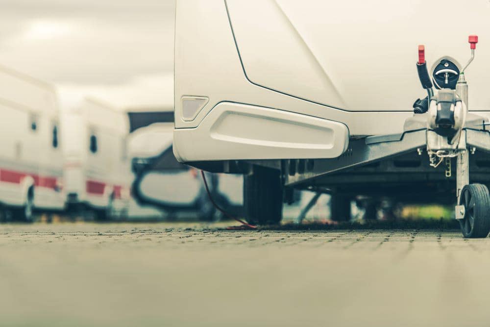 A white RV, potentially purchased from RV dealers, is parked in a parking lot.