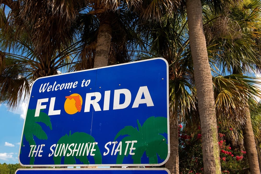 Fleetwood RV Welcome to Florida sign in front of palm trees.