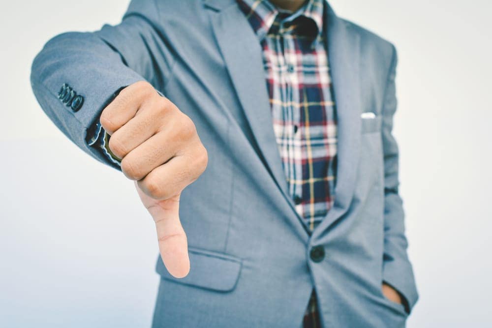 A man in a suit is giving a thumbs down sign at an RV Park.