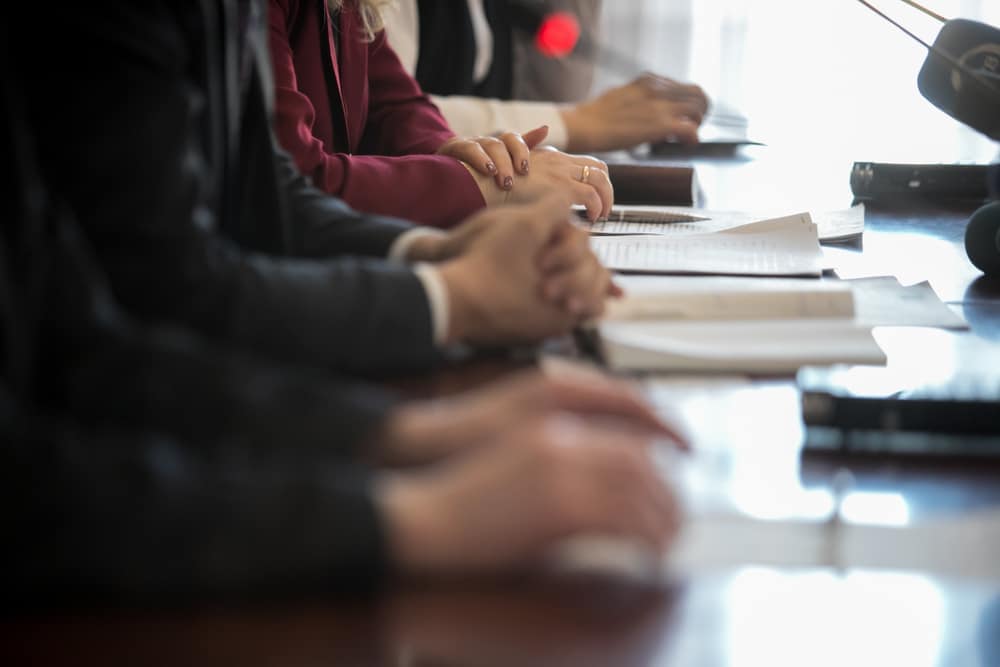 A group of business people sitting at a conference table engaged in a controversial discussion.