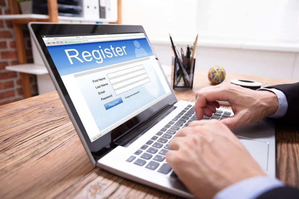A man typing on a laptop with the word Vendor Registration on it.