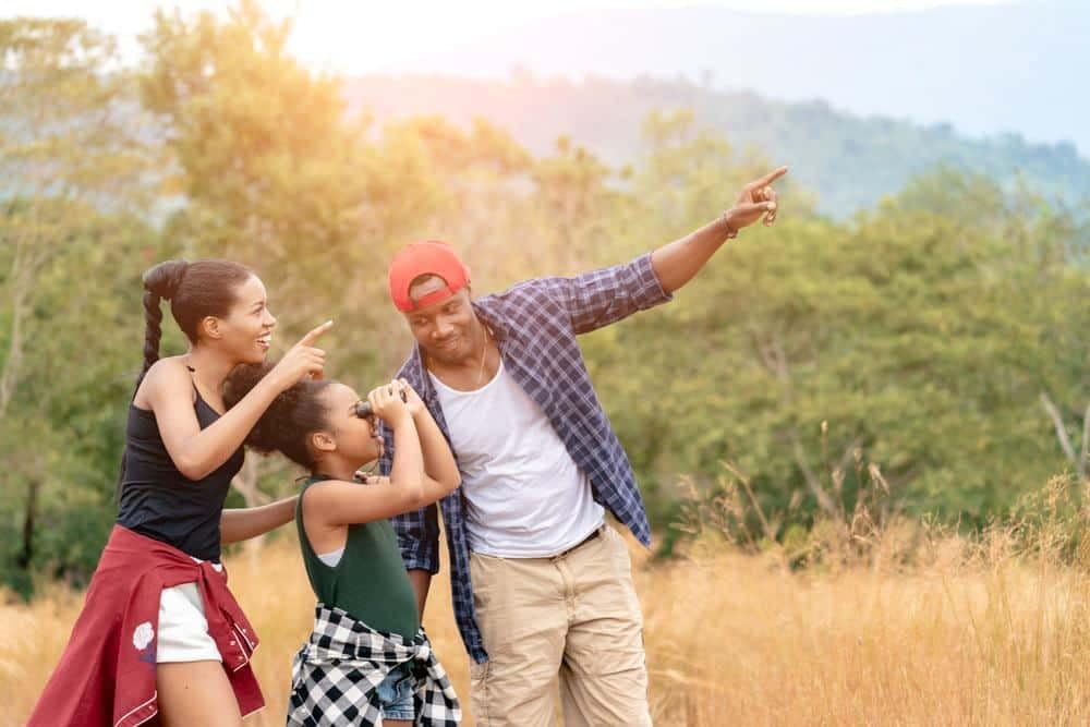 A family from Outdoor Afro is pointing at something in a field under the Sun Outdoors.