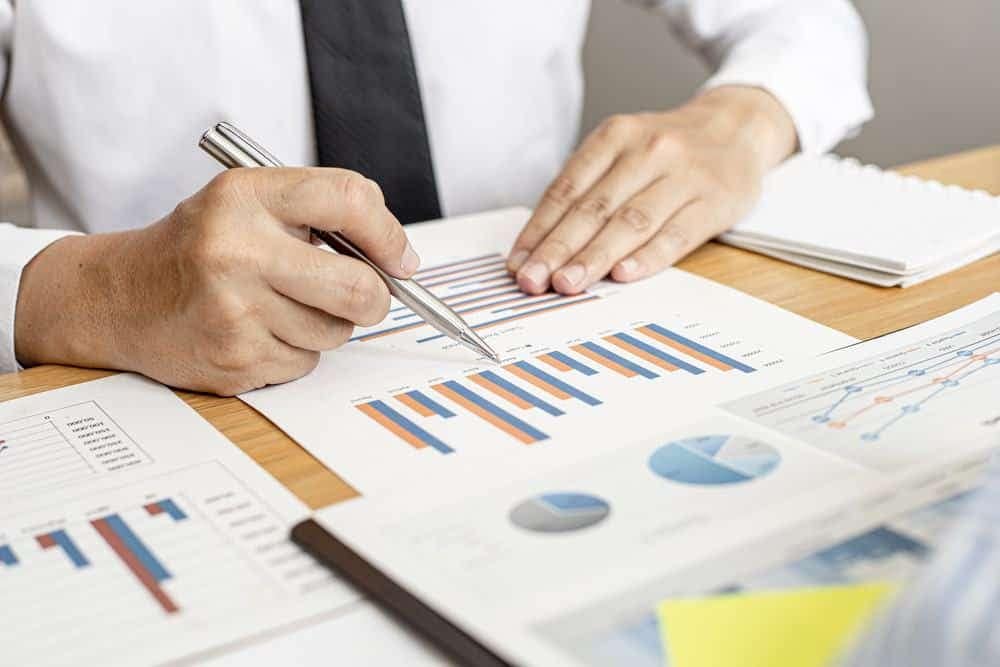 A group of Vista Outdoor business people looking at graphs on a table while discussing their record Q3 FY22 financial results.