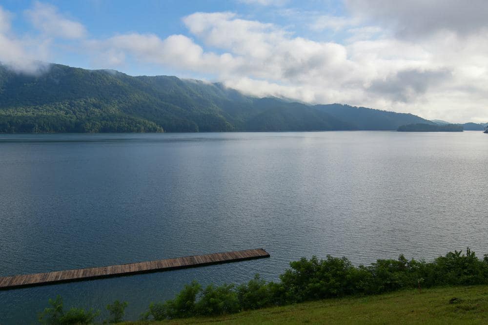 A lake with a dock and mountains in the background, owned by Cove Ridge Marina.