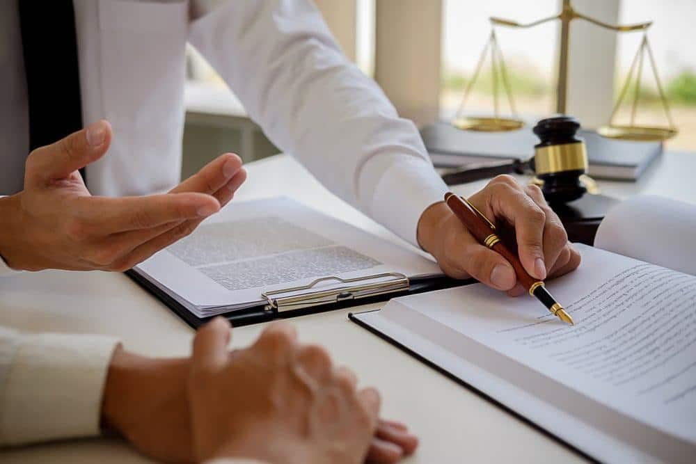 Two people signing a document at a desk in South Dakota.