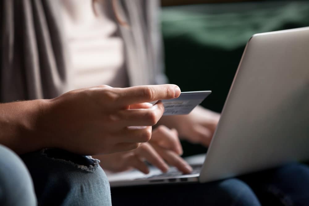 Spot2Nite launches a website featuring a person holding a credit card on a laptop.