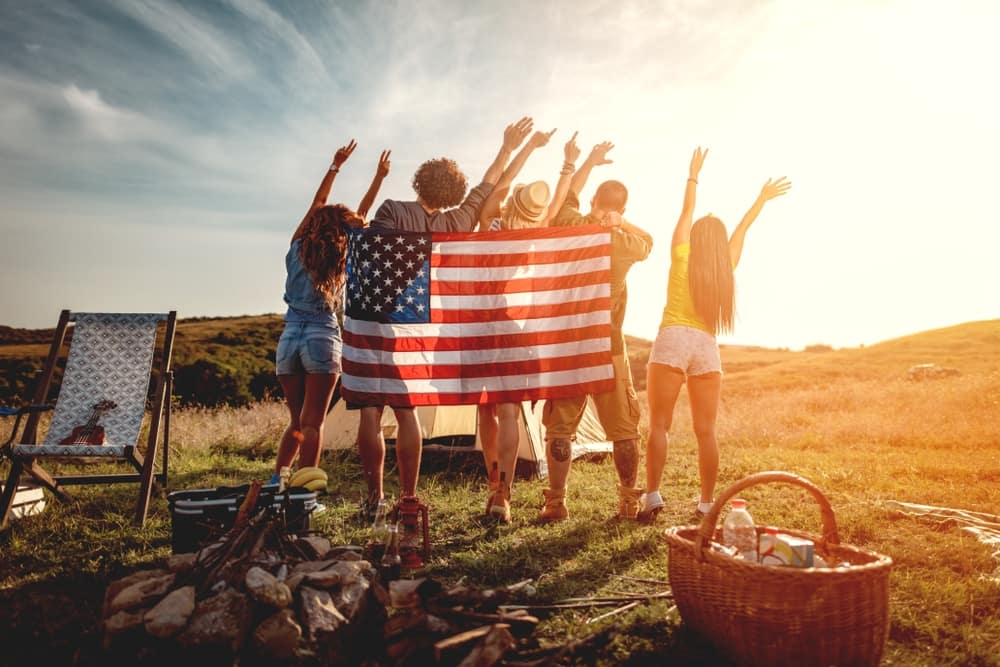 A group of people holding an American flag in a field at BIG4 Bendigo Marong Holiday Park.