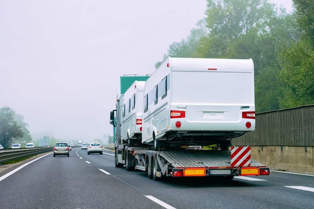A-1 Auto Transport shipped two RVs on a flatbed truck, cruising along the highway.