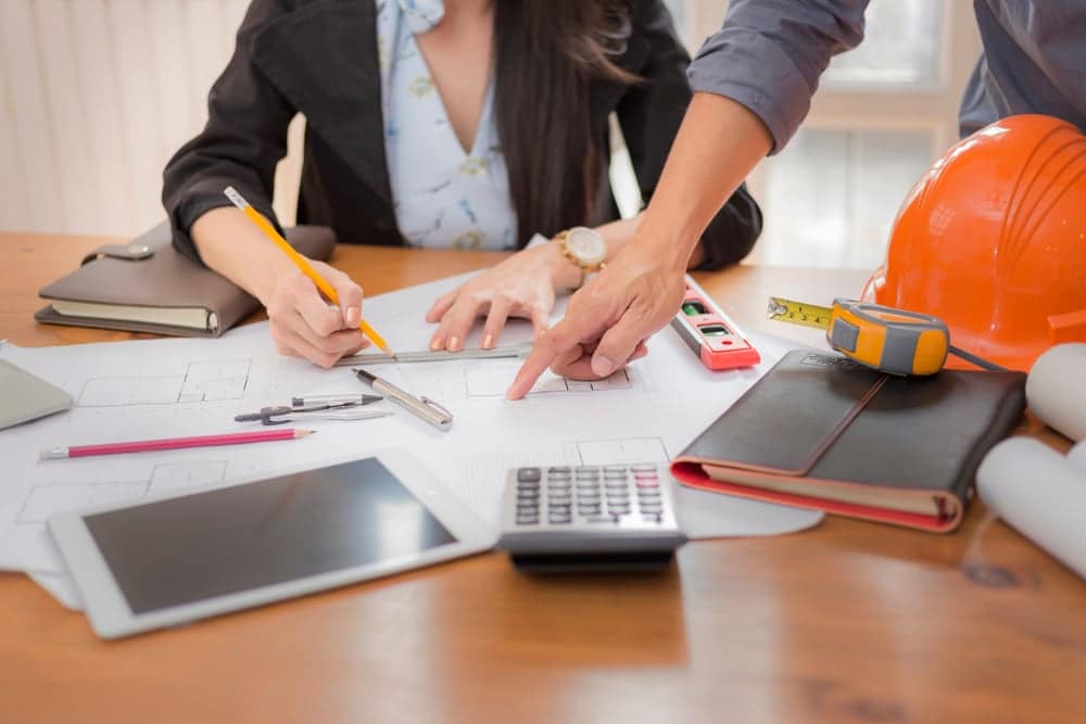 A woman and a man working on construction plans for Love's RV Park in Cañon City, acquiring the necessary permits.