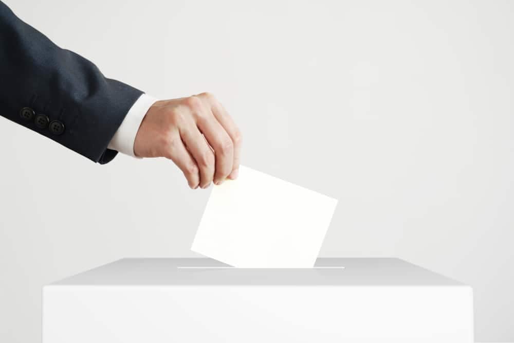 A man putting a paper into a voting box for Louisiana ARVC's Board Nominations.