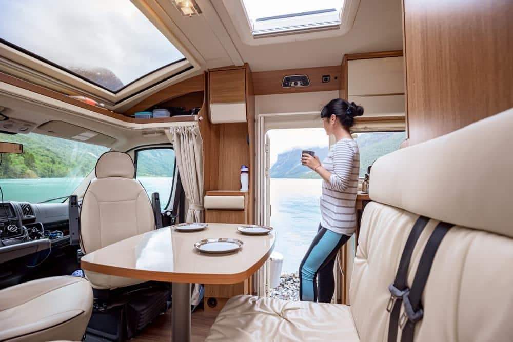 A woman participating in the Women's Alliance Fall Education Symposium within the comfort of an RV, engaged with her cell phone.