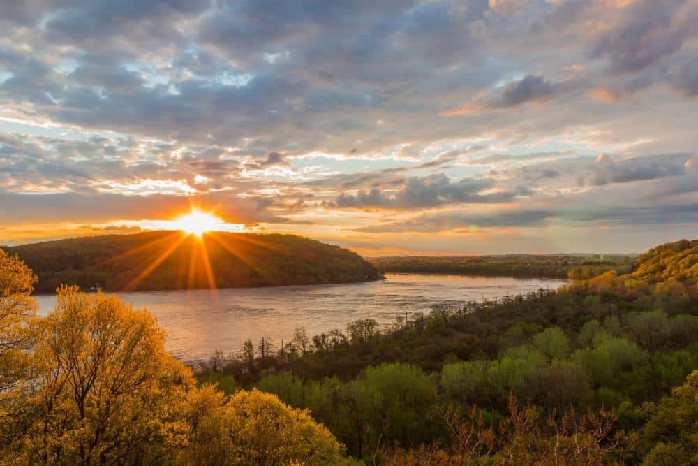 The sun is setting over the ORR river and trees in Pennsylvania, bringing a breathtaking view to the Director of Outdoor Recreation.
