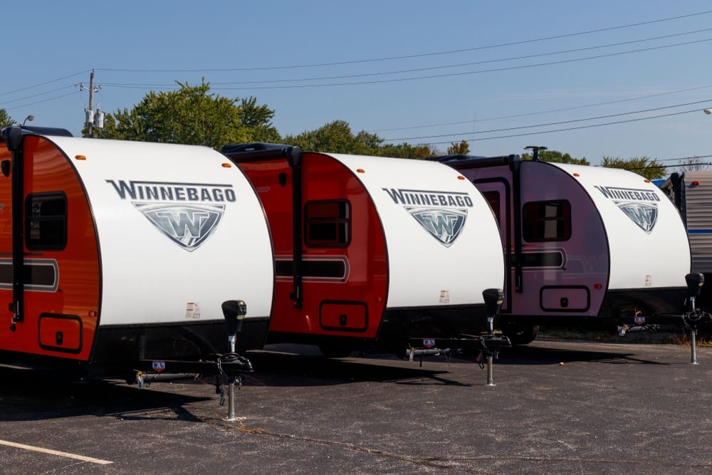 Four RVs parked in a parking lot.