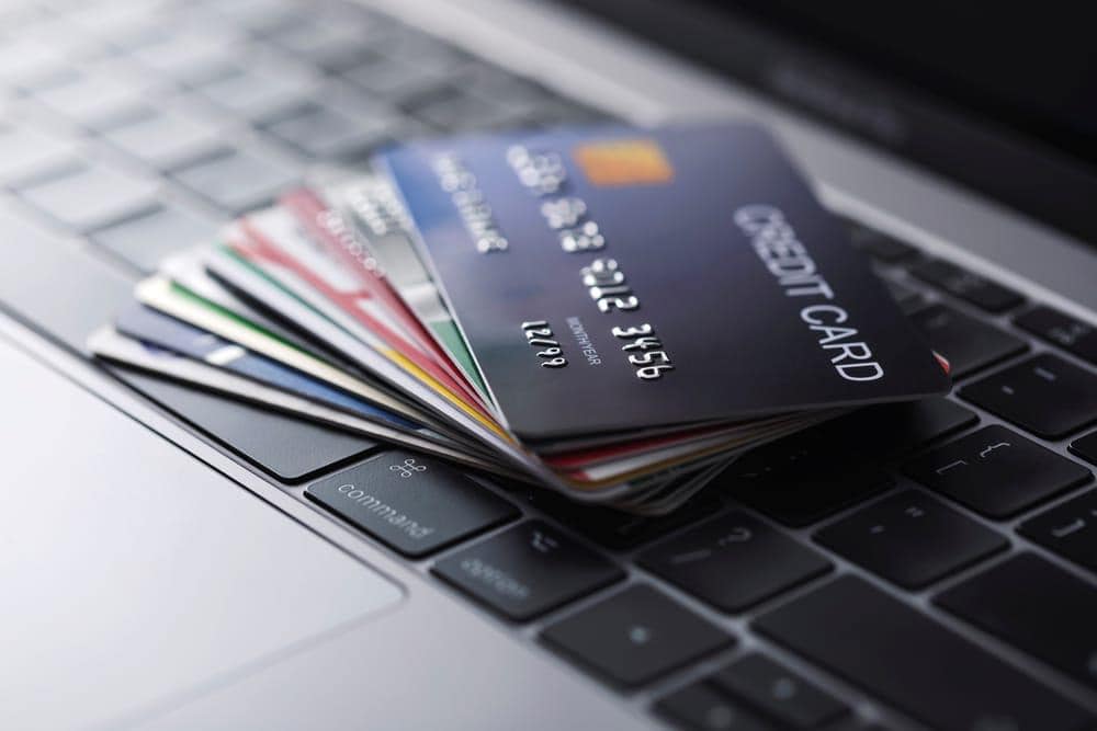 A stack of credit cards on a laptop keyboard.