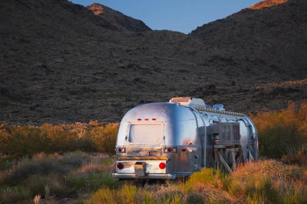 A silver airstream parked in the desert, available for Roadpass Pro Members.