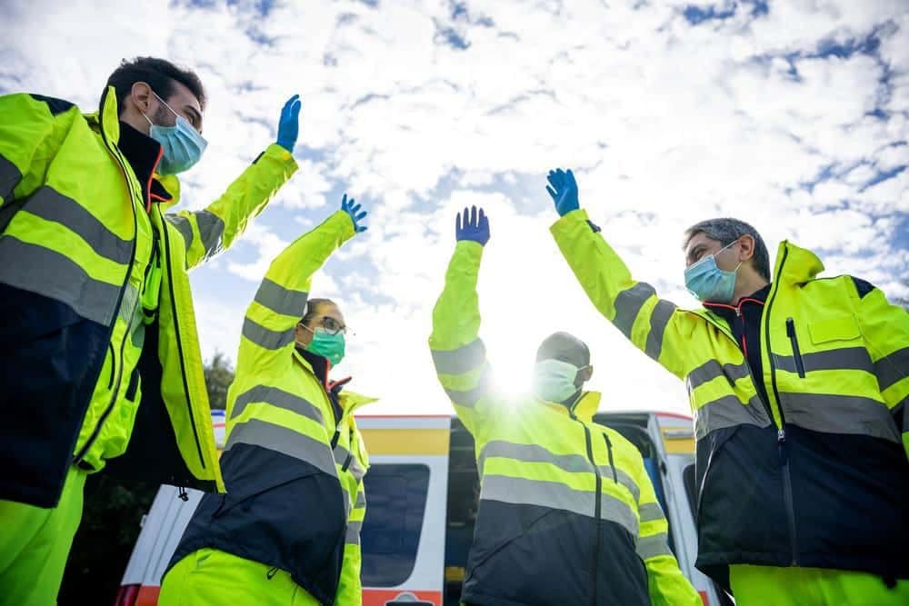 First Responder personnel in protective gear raise their hands in the air during a Blue Water event at OBX West/Currituck Sound KOA Holiday.