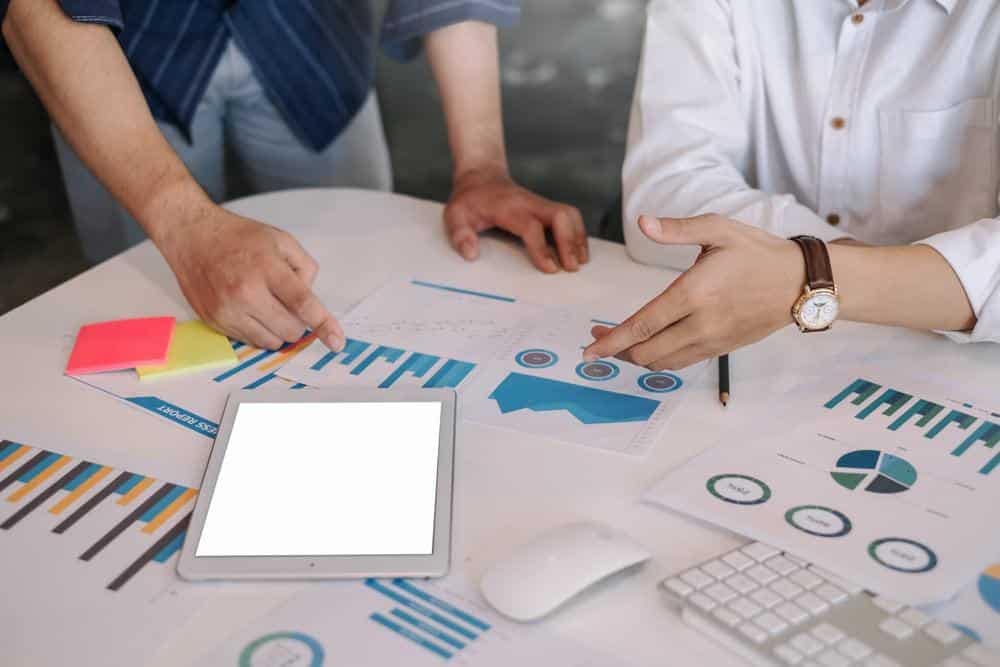 A group of people sitting around a table with a tablet and Conservation Board stock photography.