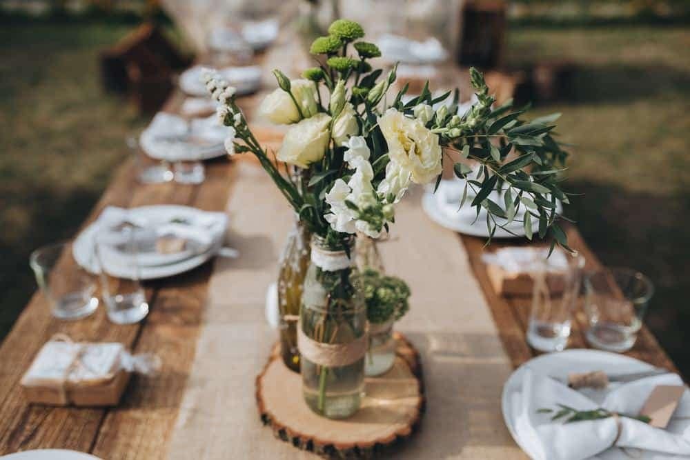 A Texan Ranch Style wooden table with flowers and plates on it, perfect for weddings at North Texas Jellystone Park.