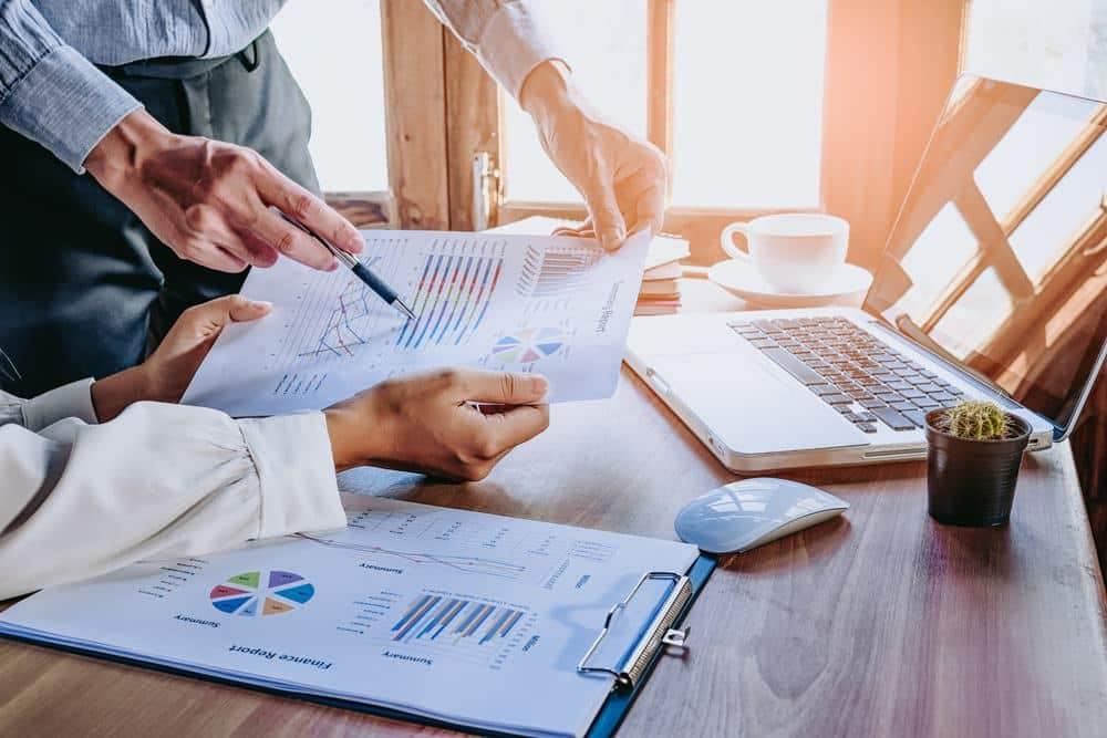 Two business people working on a spreadsheet at a desk, utilizing storage capabilities for data expansion.