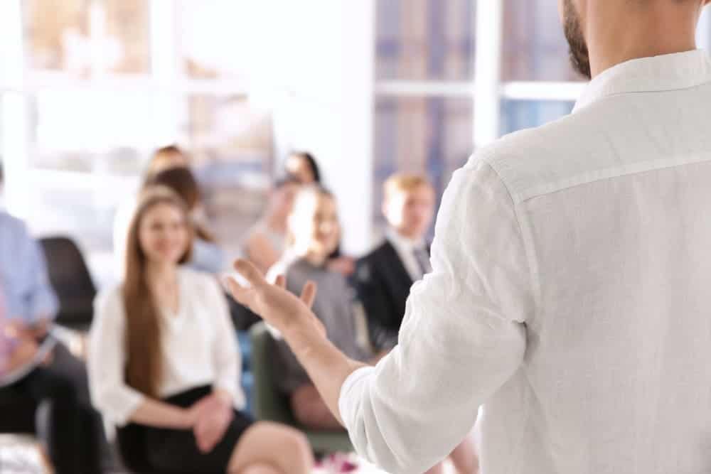 In April, a man is giving a presentation at the KOA Campground Buyer's Workshop to a group of people.