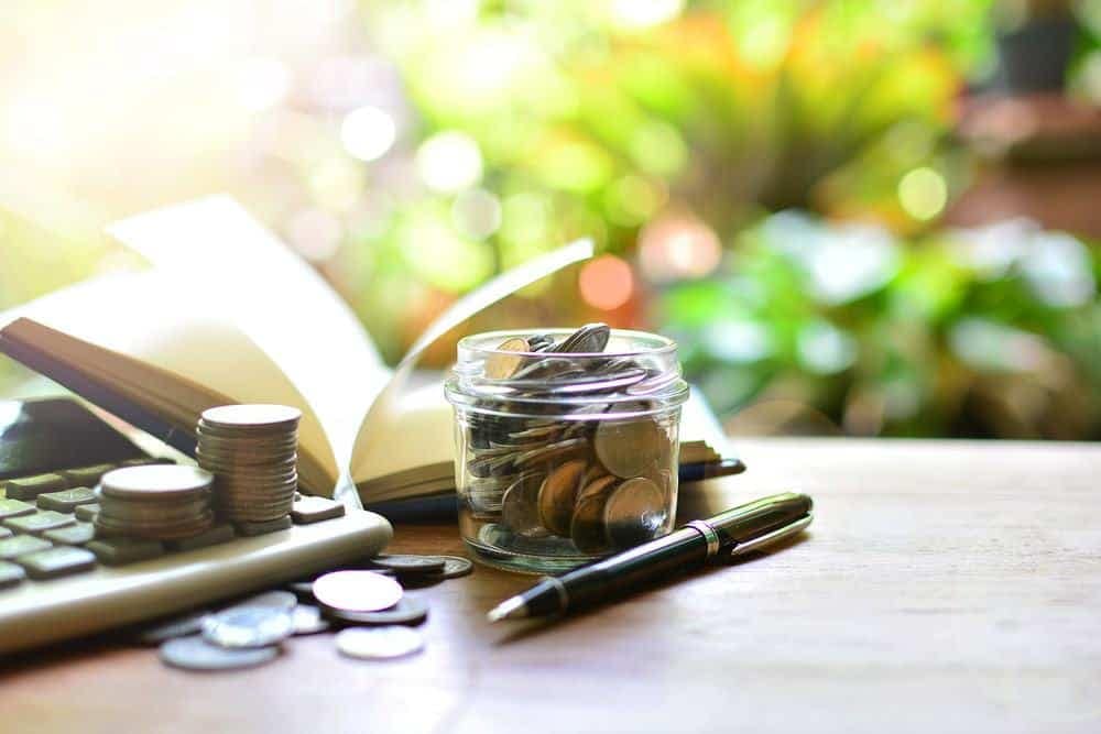 A jar of coins on a desk next to a keyboard in Colorado.