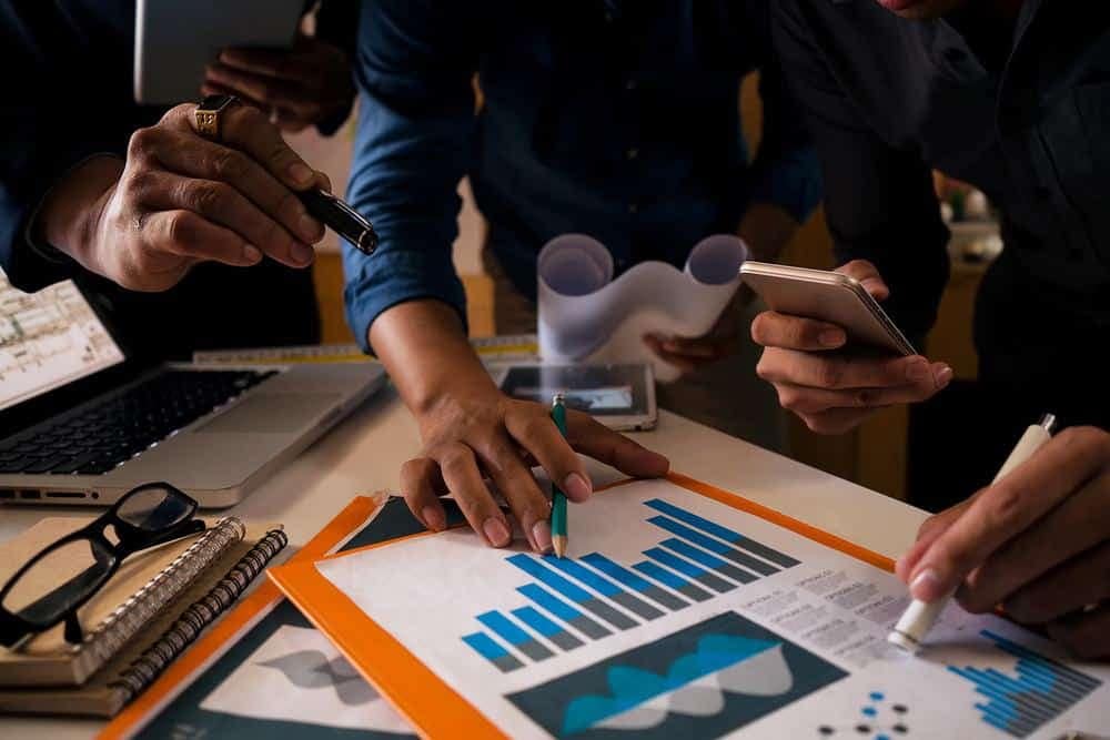 A group of business people studying the Employment Trends Index graphs on a conference board.