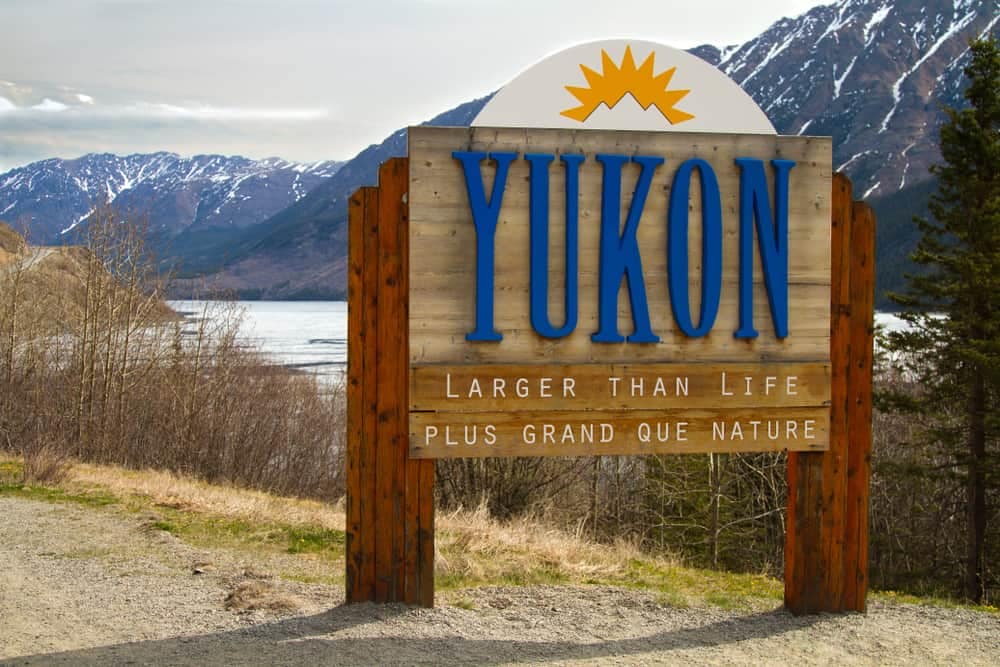 A sign for Whitehorse with mountains in the background.