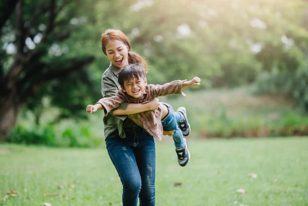 Mother and son engage children in playing at the park, surrounded by the beauty of Abraham Lincoln Birthplace National Historical Park.