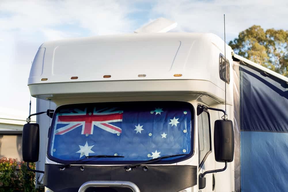 A white Victorian caravan with an Australian flag on it.
